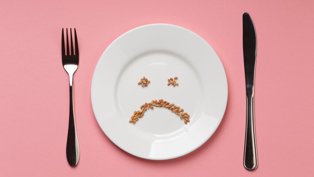 Prato com rosto triste desenhado, ideia de disturbio alimentar