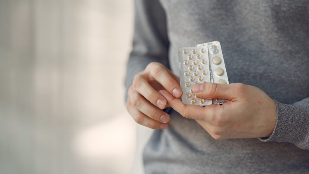 Homem segurando cartela de comprimidos