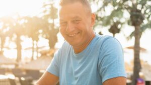 Homem idoso sorridente se exercitando no parque