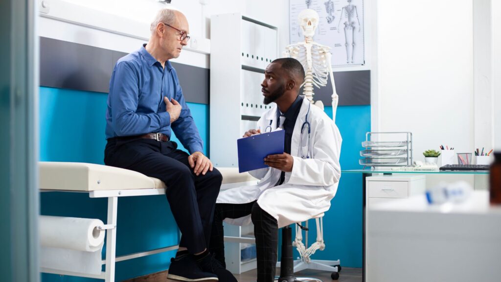 Médico com prancheta ouvindo paciente durante consulta