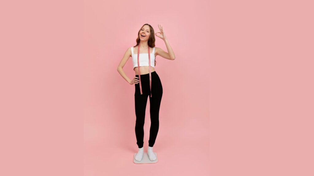 Mulher com fita métrica em fundo rosa