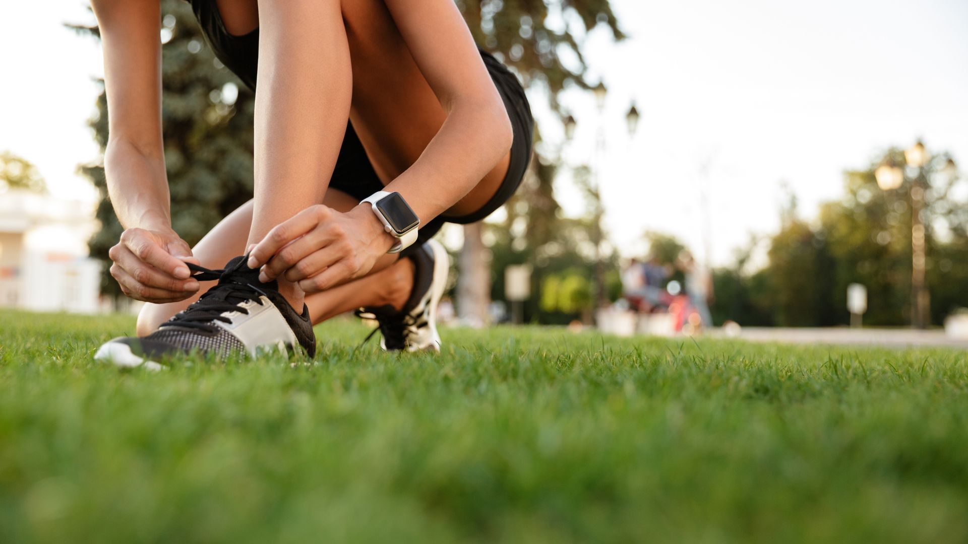 Mulher fitness amarrando o tênis para treino
