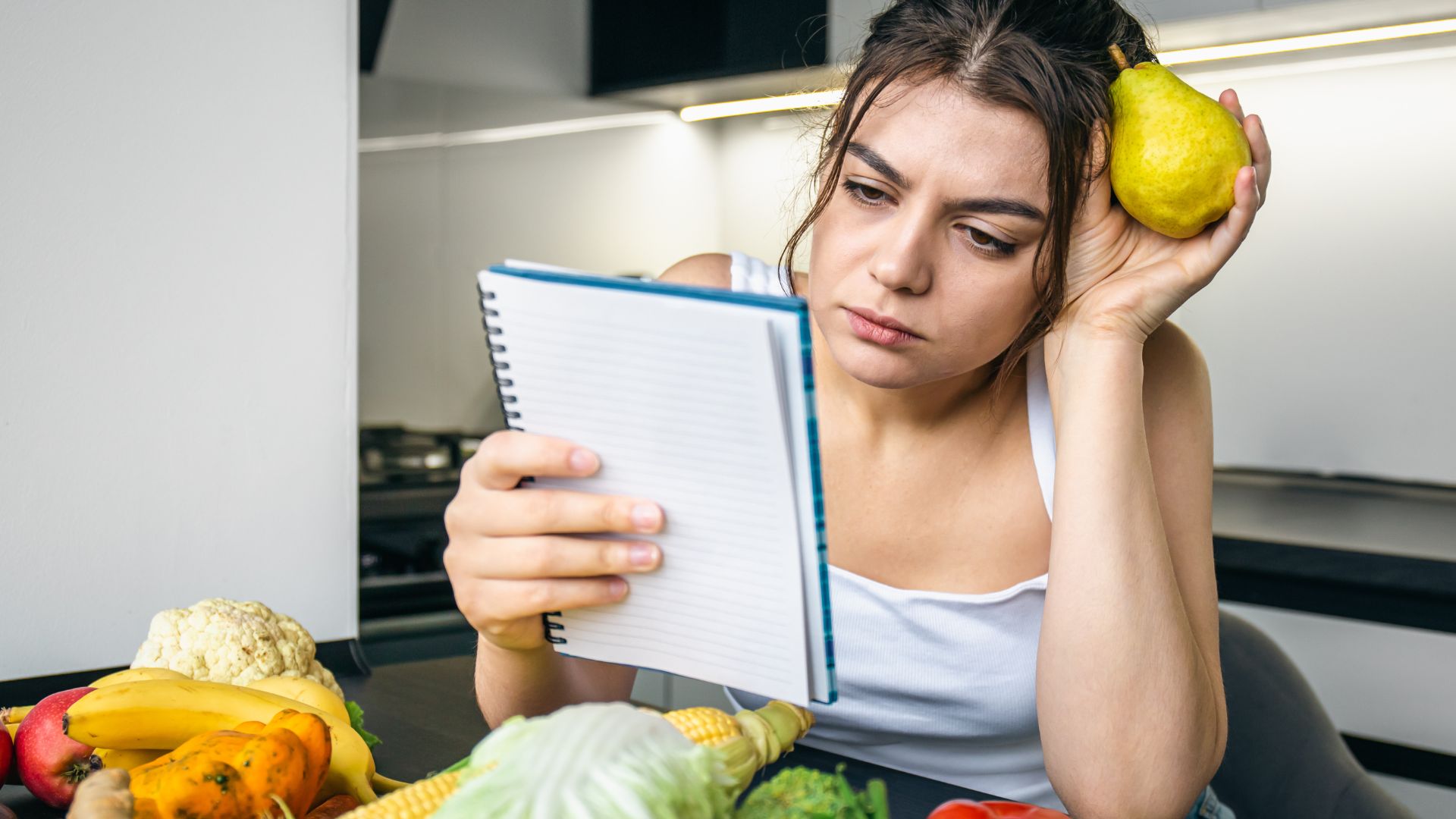 Mulher jovem na cozinha fazendo anotações