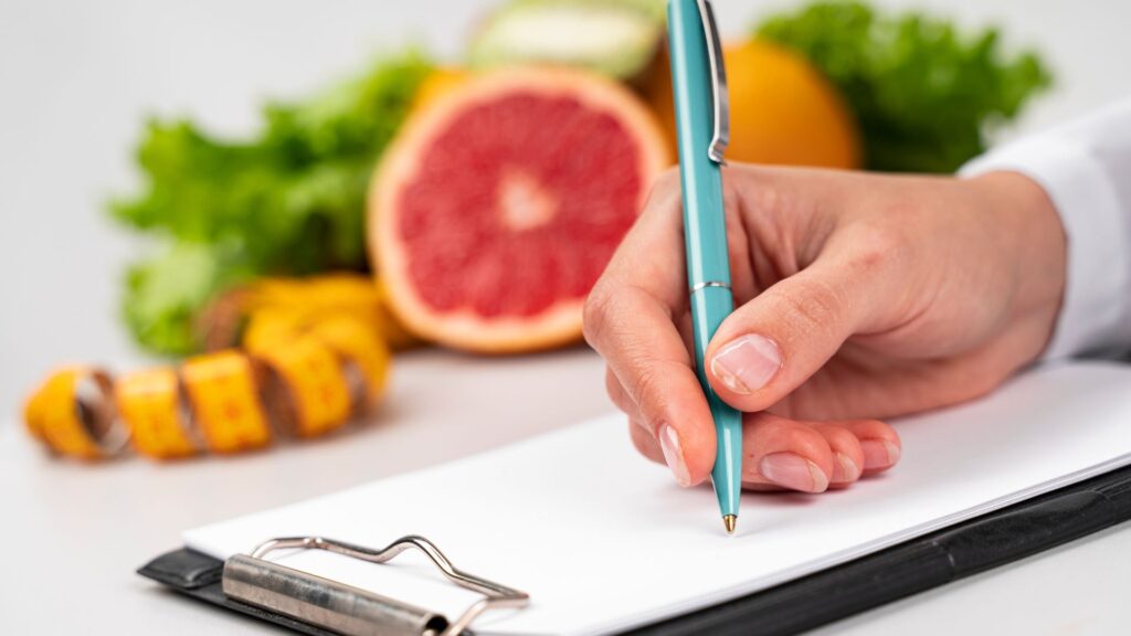 Mulher escrevendo com frutas desfocadas ao fundo
