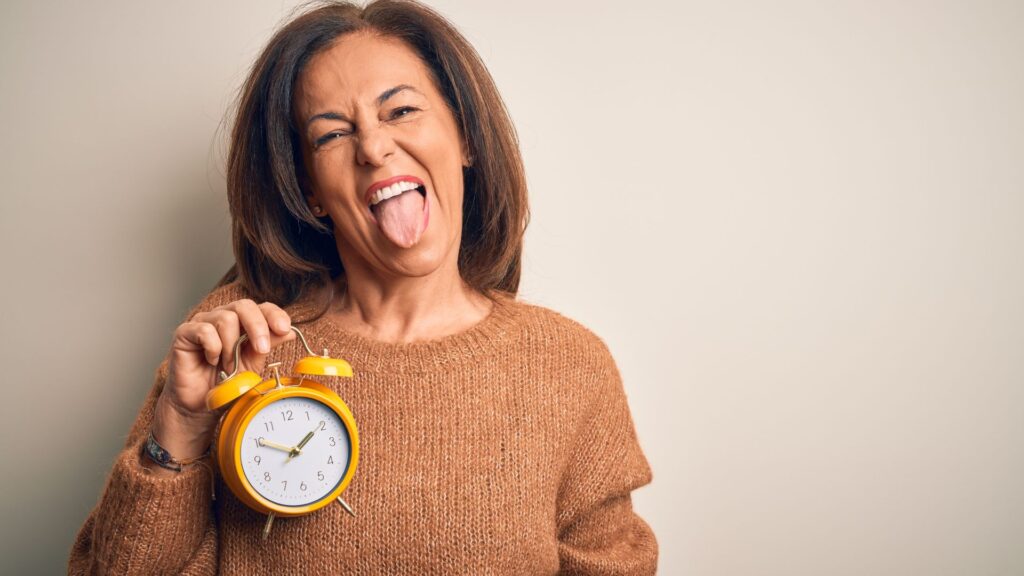 Mulher segurando relógio representando menopausa