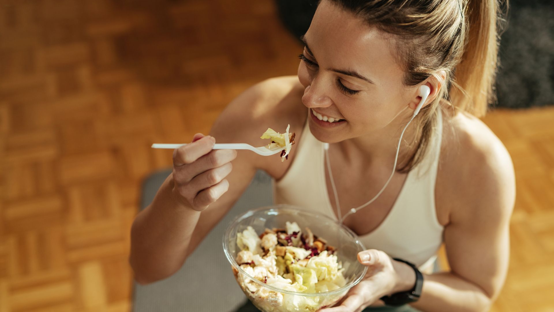 Mulher atleta comendo salada após treino