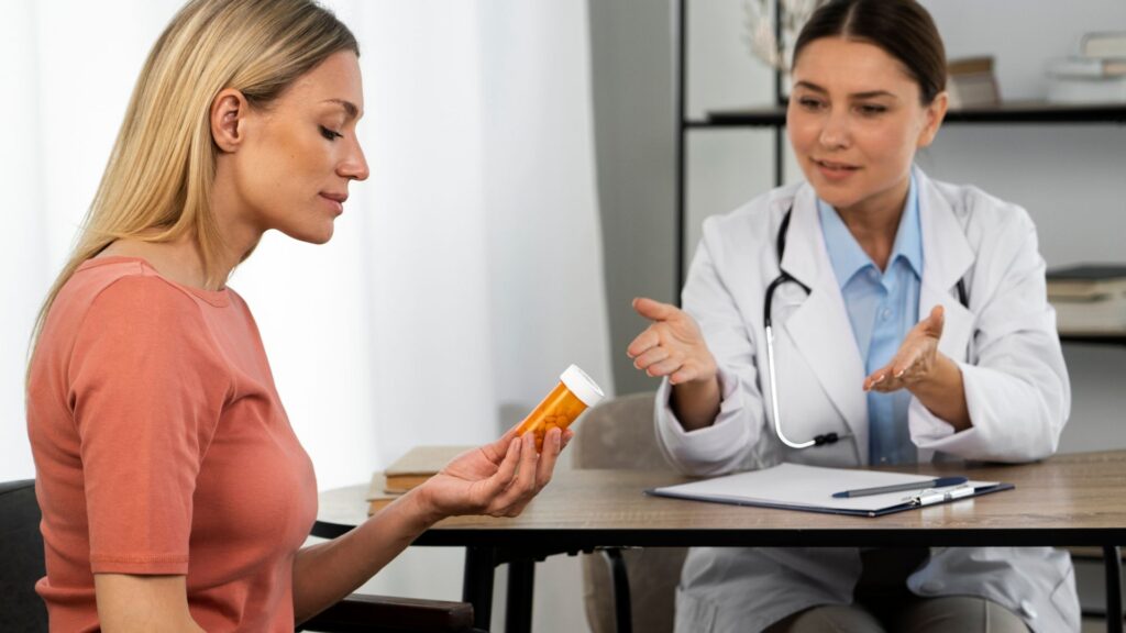 Mulher de lado segurando frasco de remédios