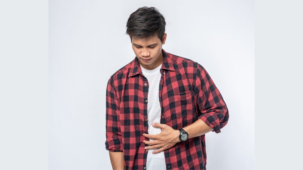 Homem com dor de estômago segurando a barriga