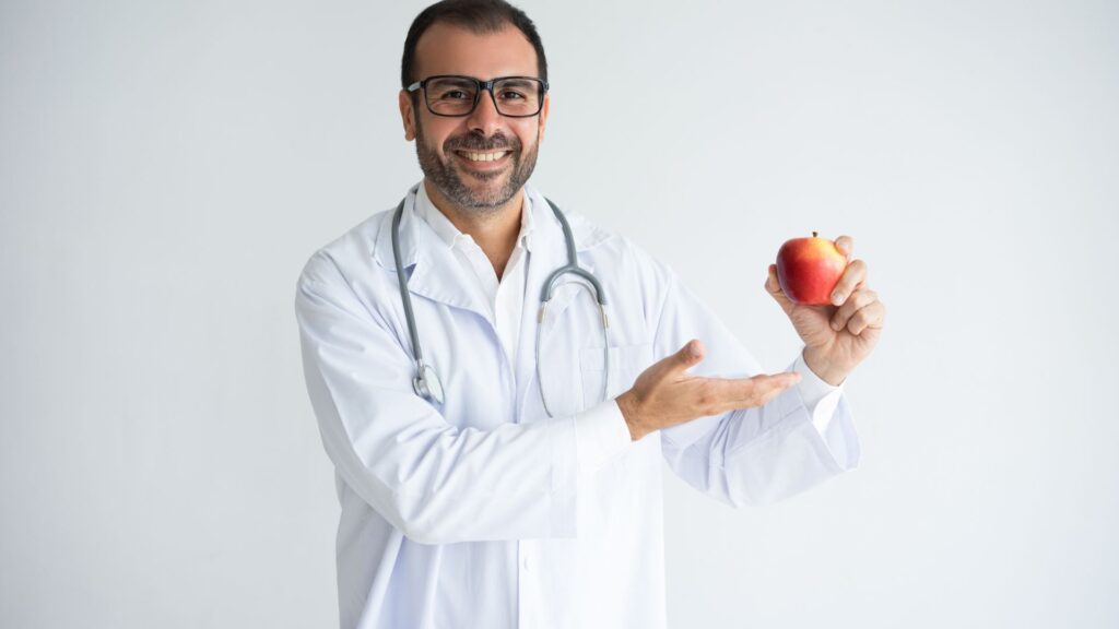 Médico sorridente oferecendo maçã saudável