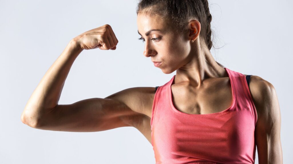 mulher musculosa mostrando o muque, ganho de massa muscular