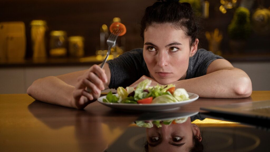 mulher olhando garfo com comida