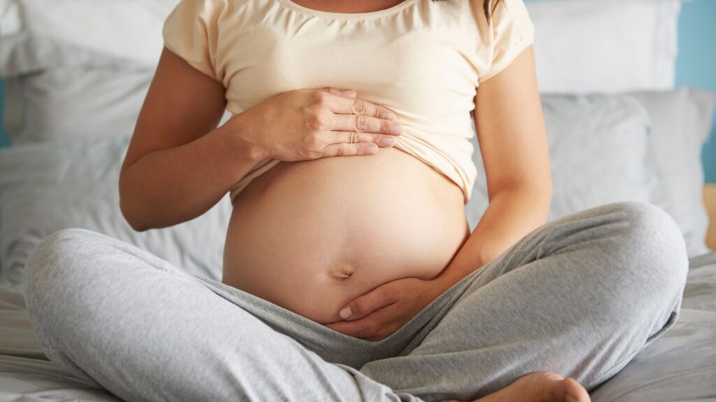 gravida sentada mostando a barriga